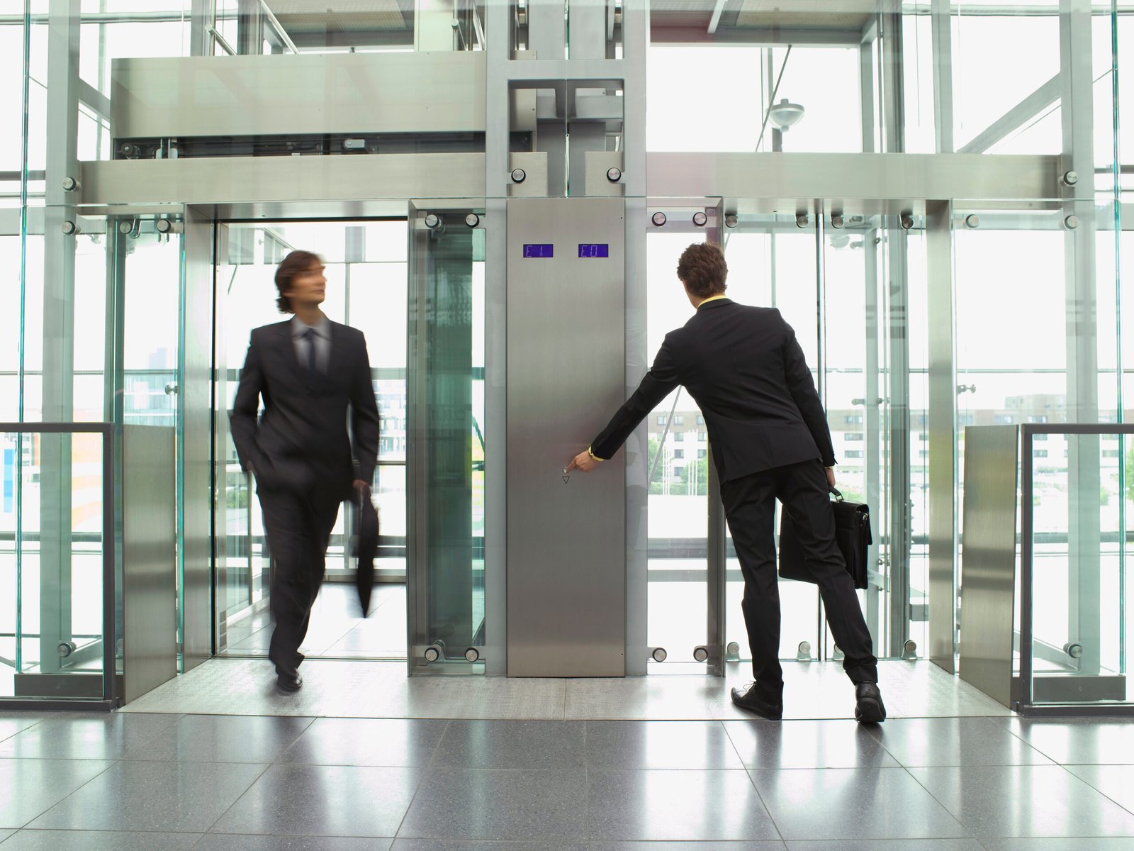 Business professionals using a modern office elevator