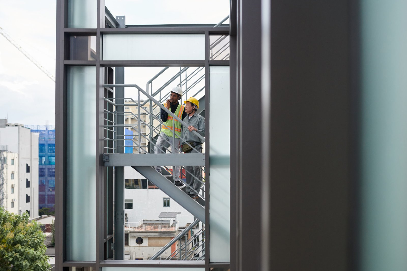Construction team on a high-rise staircase overlooking the city
