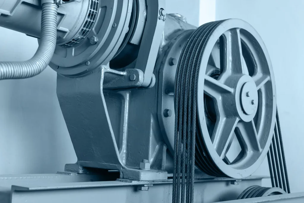 An elevator traction machine with a grooved sheave and suspension ropes
